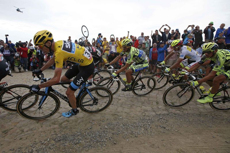 © Reuters. Team Sky rider Froome of Britain, race leader and yellow jersey holder, and Tinkoff-Saxo rider Alberto Contador of Spain cycle on a cobble-stoned section during the 4th stage of the 102nd Tour de France cycling race from Seraing in Belgium to Cambrai