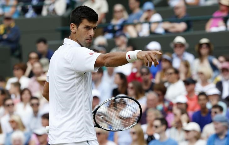 © Reuters. Novak Djokovic of Serbia requests his towel from a ball girl during his match against Kevin Anderson of South Africa at the Wimbledon Tennis Championships in London