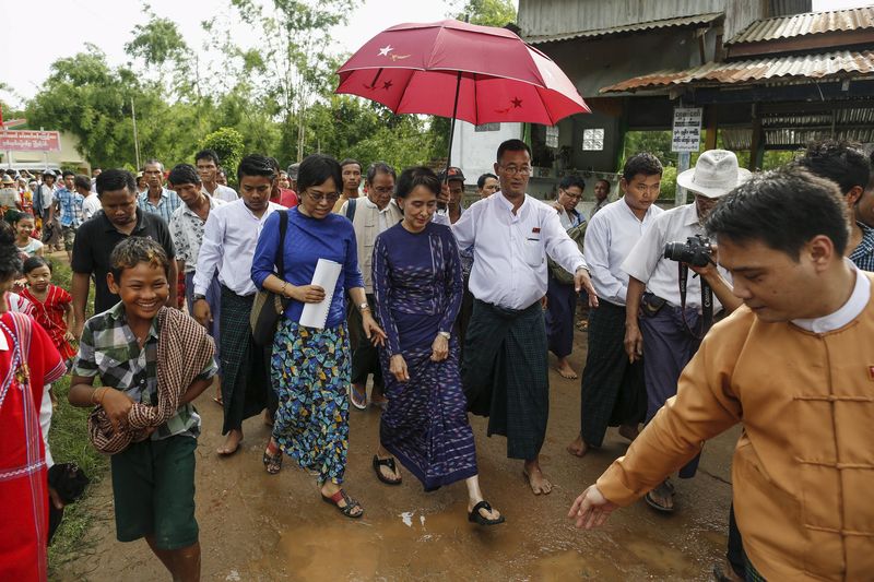 © Reuters. Suu Kyi walks in Warheinkha village