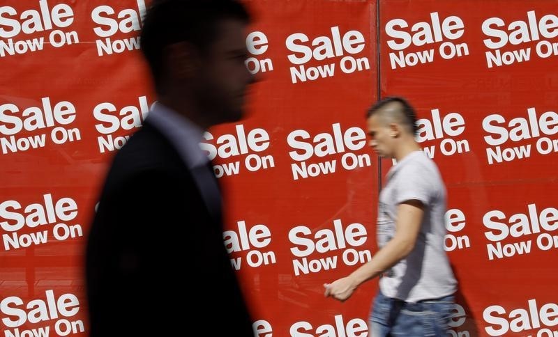 © Reuters. Pedestrians walk past sale signs in the windows of a shop on Oxford Street in London