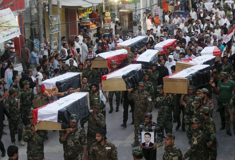 © Reuters. Combatentes xiitas levam caixões de soldados mortos pelo Estado Islâmico