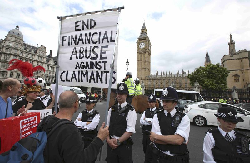 © Reuters. Demonstrators protest as Britain's Chancellor of the Exchequer George Osborne delivers his budget in London