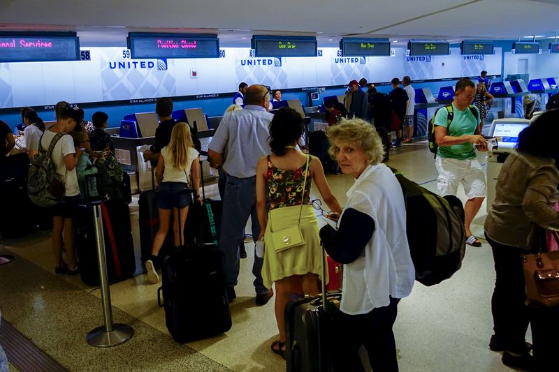 © Reuters. People wait in line at the United Airline counter in Newark International Airport, New Jersey