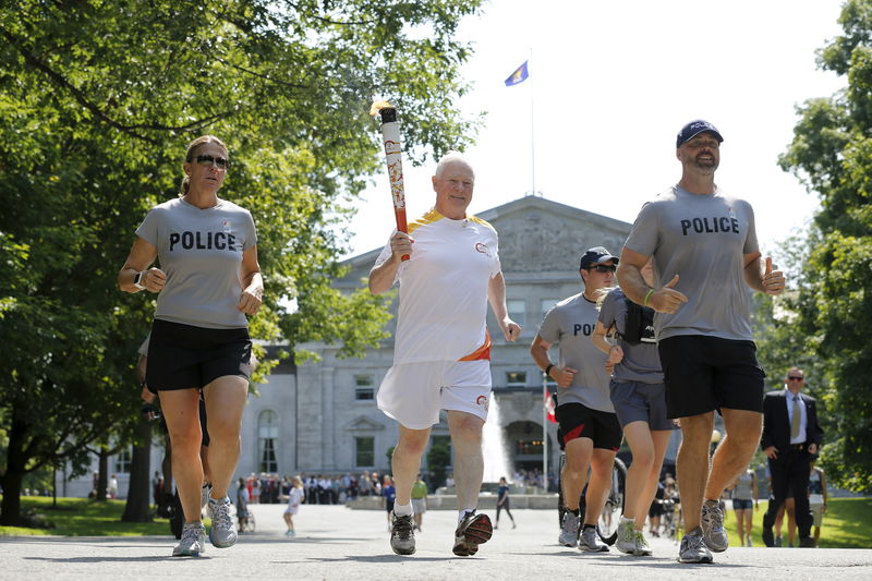 © Reuters. Governador do Canadá, David Johnston, carrega a tocha olímpica em Ottawa