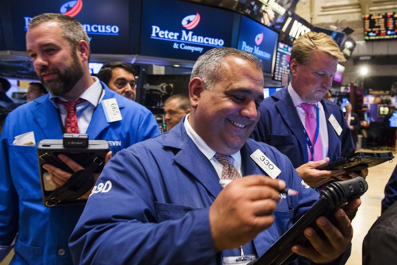 © Reuters. Traders laugh as they close out their trades shortly after the closing bell on a day that saw a several hour long stoppage on the floor of the New York Stock Exchange