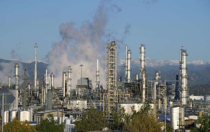 © Reuters. An oil refinery is seen with the Rocky Mountains freshly covered with snow in the background in Denver