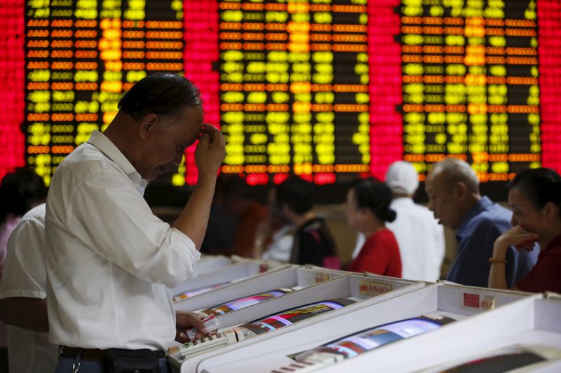 © Reuters. Investors look at computer screens showing stock information at a brokerage house in Shanghai