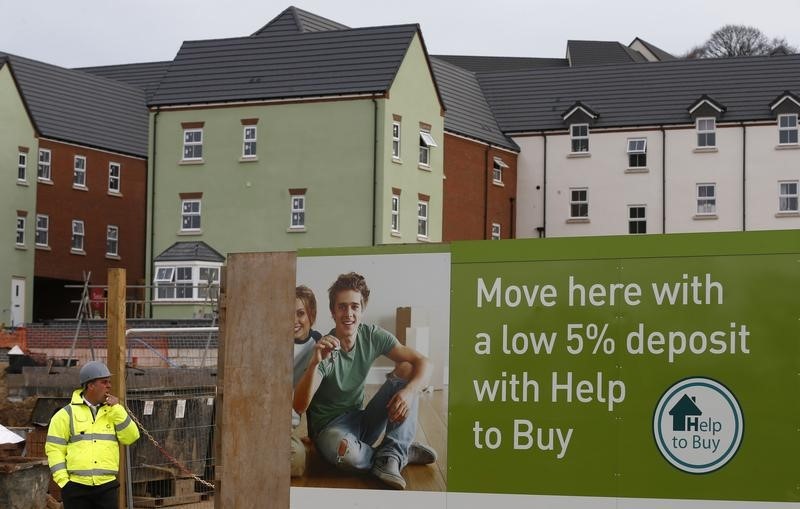 © Reuters. A builder stands by a "help to buy" advert on a Barratt Homes building site in Nuneaton
