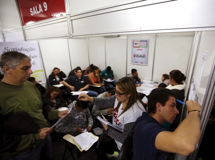 © Reuters. Pessoas preenchem fichas de emprego em São Paulo