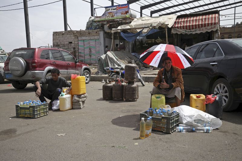 © Reuters. Vendedores aguardam clientes para comprar combustível em Sanaa