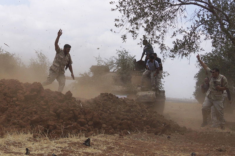 © Reuters. Free Syrian Army fighters fire from a tank during what they said was an offensive against the forces of Syria's PresidentAssad in the southern city of Deraa, Syria