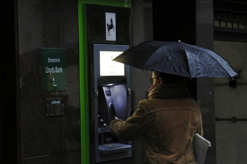 © Reuters. A woman uses a Lloyd's Bank cash machine in London