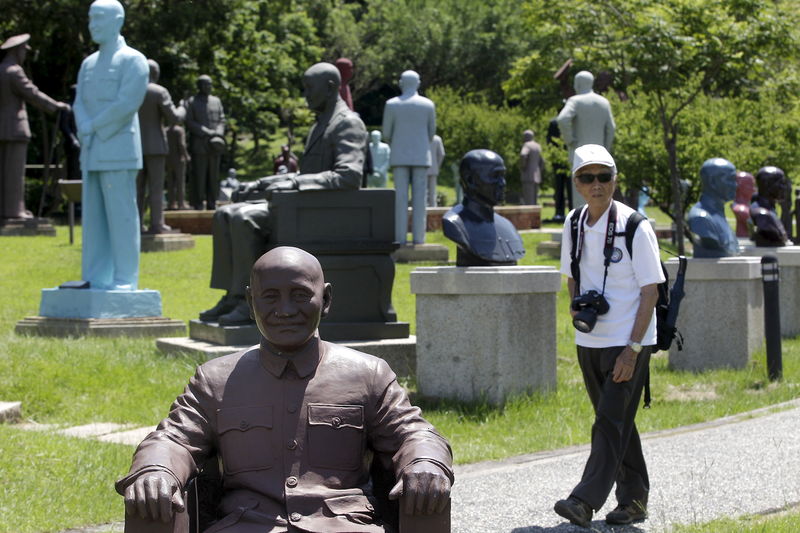 © Reuters. A man walks in between statues of the late president and Nationalist leader Chiang Kai-shek in Taoyuan