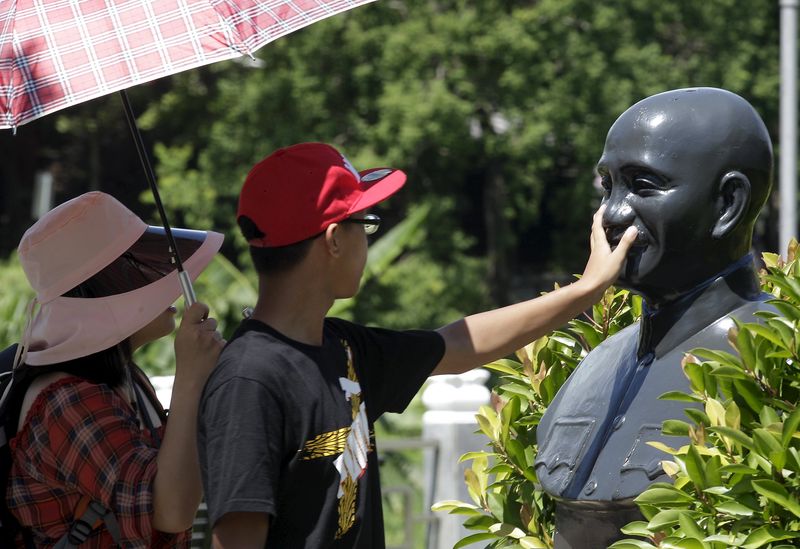 © Reuters. A person touches a statue of the late president and Nationalist leader Chiang Kai-shek in Taoyuan