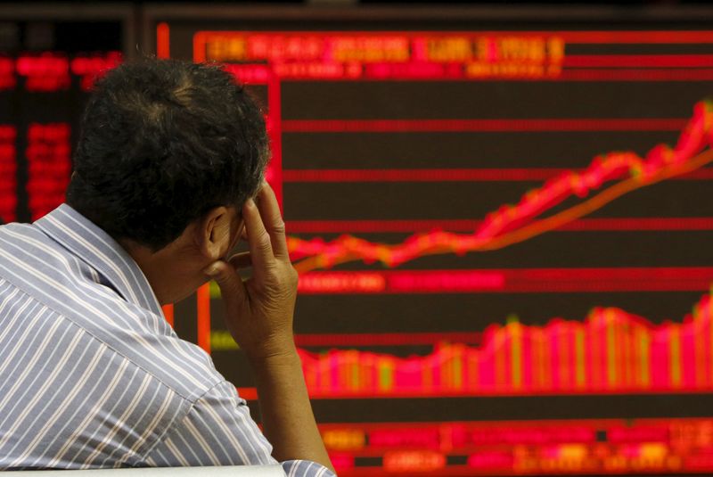 © Reuters. An investor watches an electronic board showing stock information at a brokerage office in Beijing