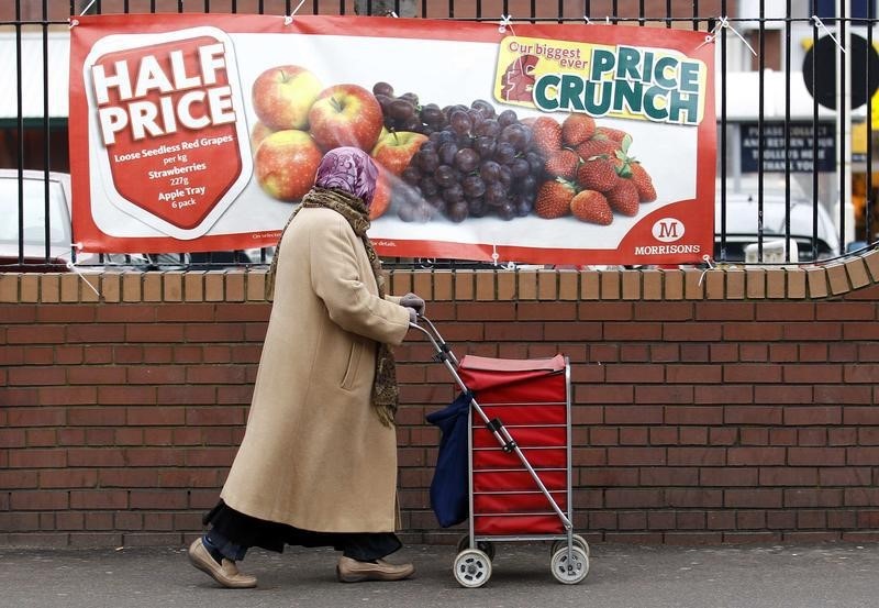 © Reuters. A woman walks past a shop advertisement in south London