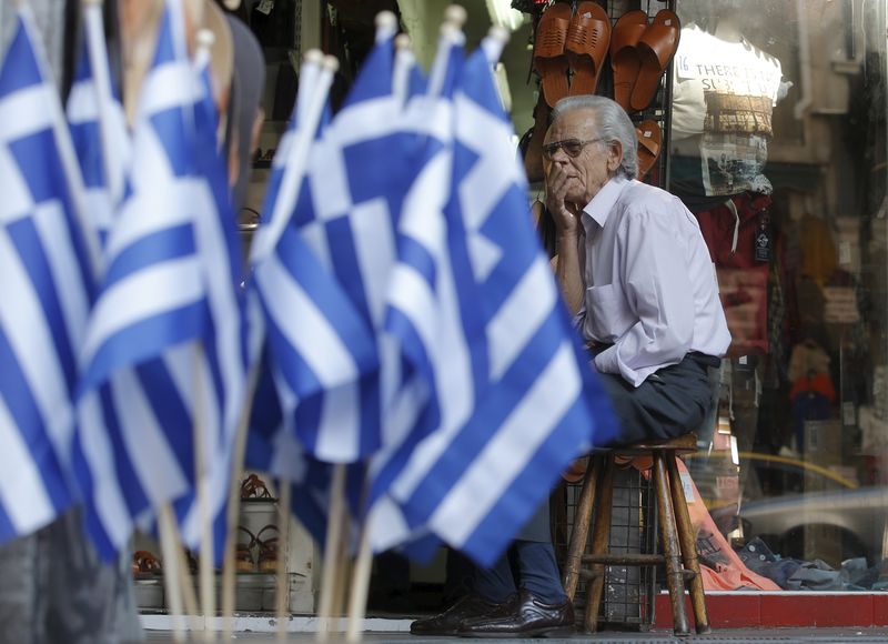 © Reuters. Vendedor espera por clientes do lado de fora de loja em Atenas