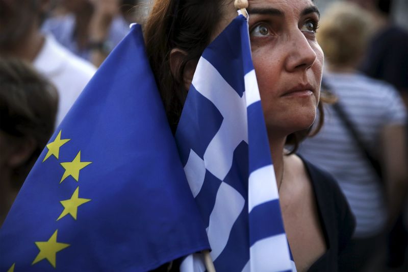 © Reuters. Manifestate pró-euro segura bandeira da UE e da Grécia durante protesto em Atenas