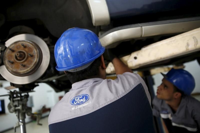 © Reuters. The corporate logo of Ford is seen on the uniform of a mechanic at a Ford branch in Caracas 