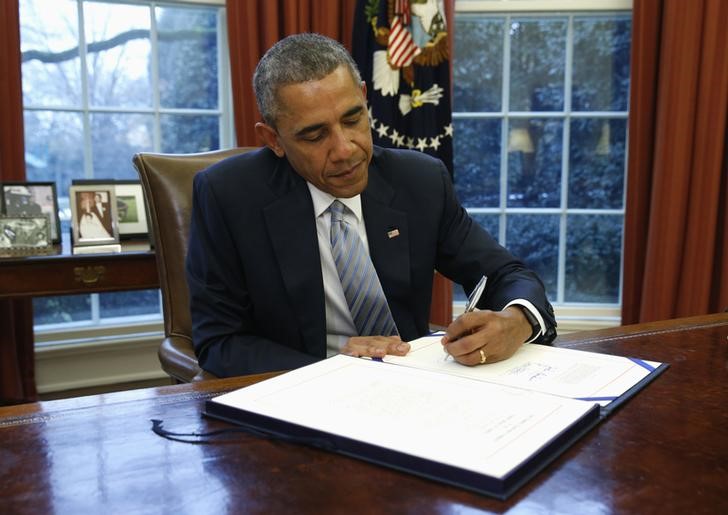 © Reuters. U.S. President Barack Obama signs H.R. 240 - Department of Homeland Security Appropriations, Act 2015,  in the Oval Office of the White House