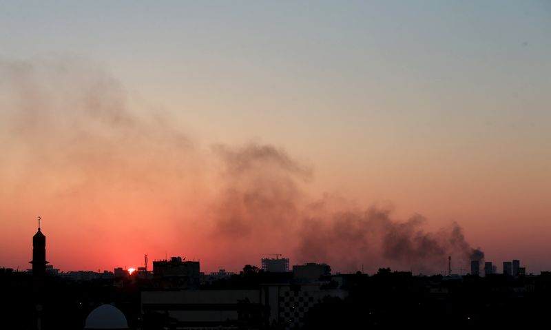 © Reuters. Black smoke billows in the sky above areas where clashes are taking place between pro-government forces, who are backed by the locals, and the Shura Council of Libyan Revolutionaries, an alliance of former anti-Gaddafi rebels