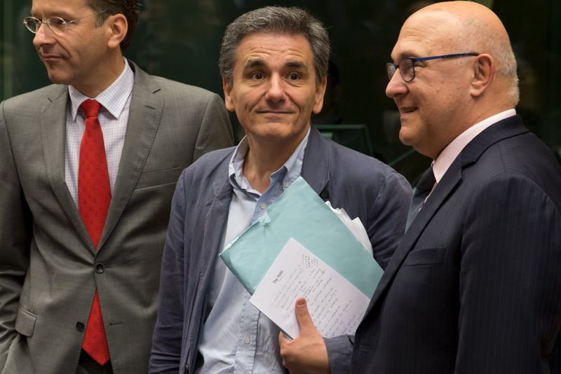 © Reuters. Newly appointed Greek Finance Minister Tsakalotos is welcomed by Eurogroup President Dijsselbloem and French Finance Minister Sapin at a euro zone finance ministers meeting in Brusselss