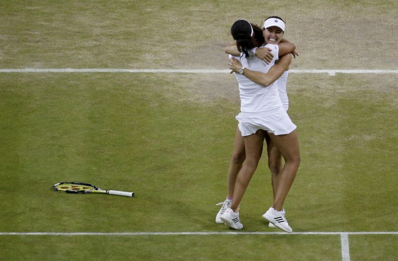 © Reuters. Martina Hingis of Switzerland and Sania Mirza of India celebrate after winning their Women's Doubles Final match against Elena Vesnina and Ekaterina Makarova of Russia at the Wimbledon Tennis Championships in London