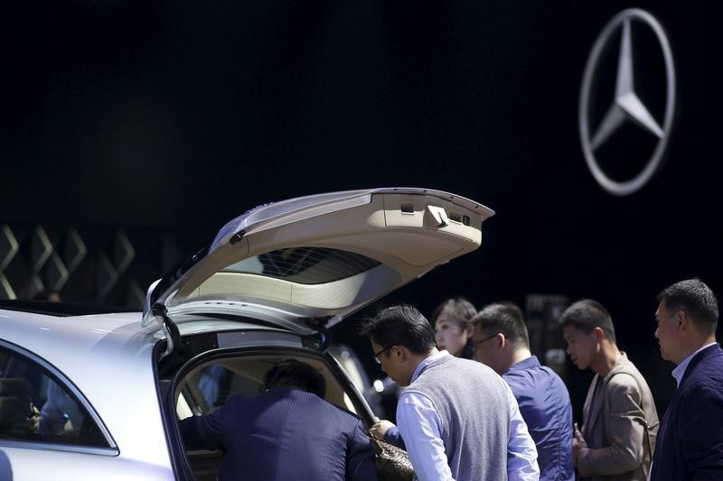 © Reuters. Attendees look at a Mercedes-Benz car during a presentation at the 16th Shanghai International Automobile Industry Exhibition in Shanghai