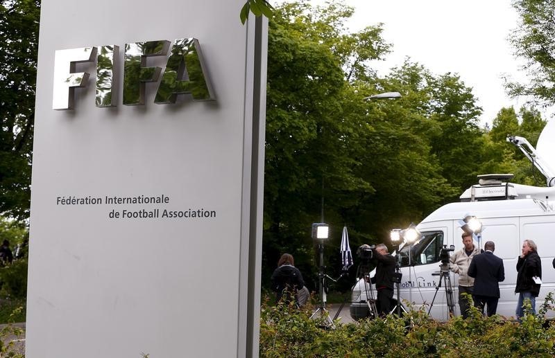 © Reuters. Members of the media stand in front of the entrance of the FIFA headquarters in Zurich