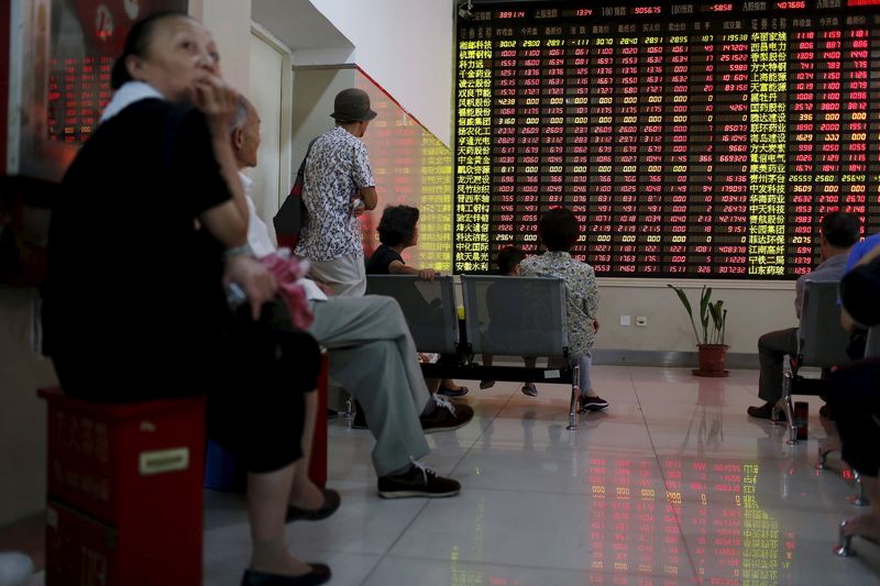 © Reuters. Investors look at an electronic board showing stock information at a brokerage house in Shanghai