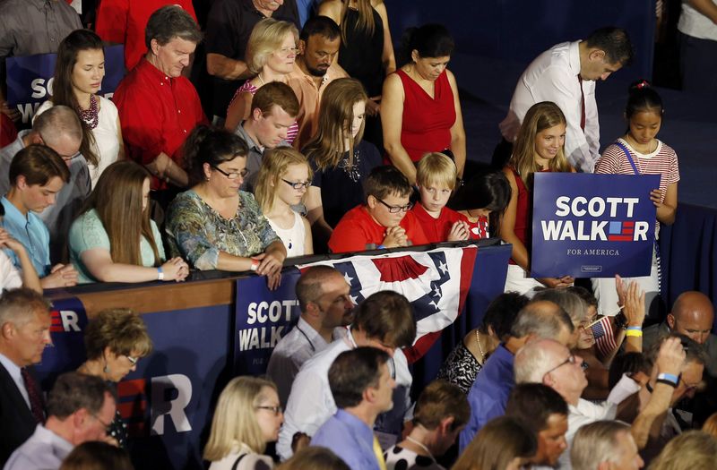 © Reuters. Supporters bow their heads in prayer before U.S. Republican presidential candidate and Wisconsin Governor Scott Walker formally announces his campaign for the 2016 Republican presidential nomination during a kickoff rally in Waukesha