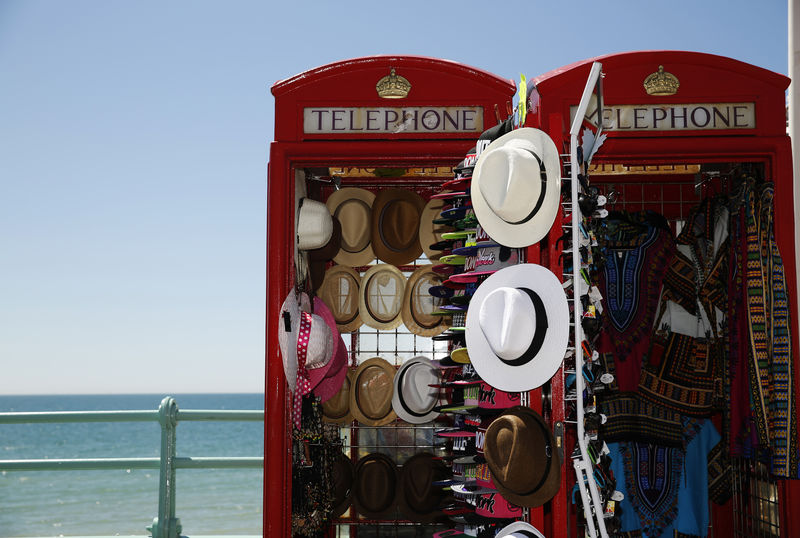 © Reuters. Sun hats are seen for sale in converted telephone boxes on a hot Summer day at Brighton beach