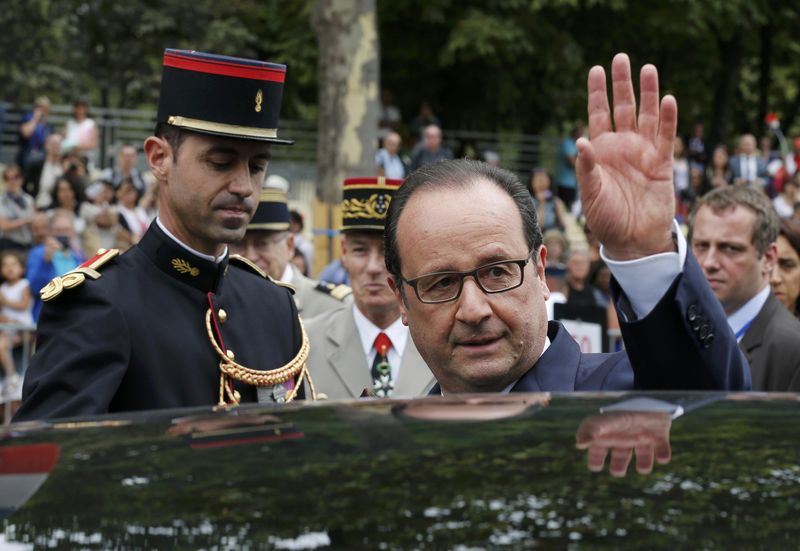 © Reuters. French President Francois Hollande waves as he enters his car after the traditional Bastille Day military parade on the Place de la Concorde in Paris