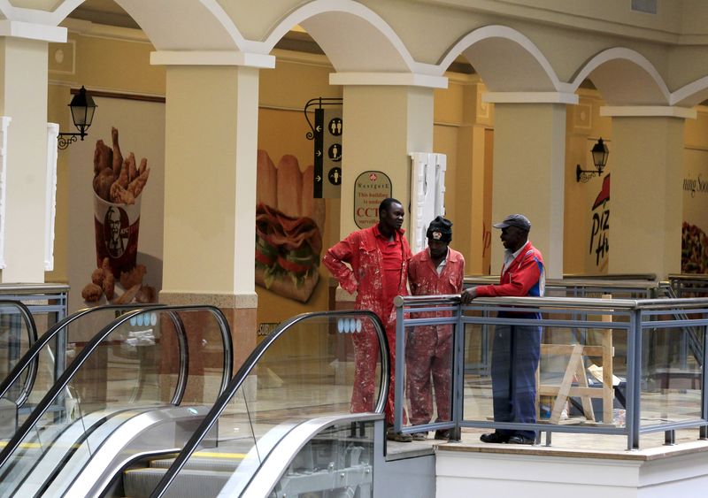 © Reuters. Workers stand in a section of the reopened Westgate shopping mall, which was closed in the aftermath of an attack by militant gunmen in September 2013 that killed 67 people and injured many more, in capital Nairobi