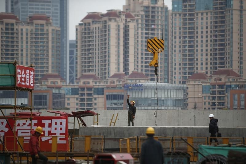 © Reuters. Labourers work at a construction site for a new building in Shanghai