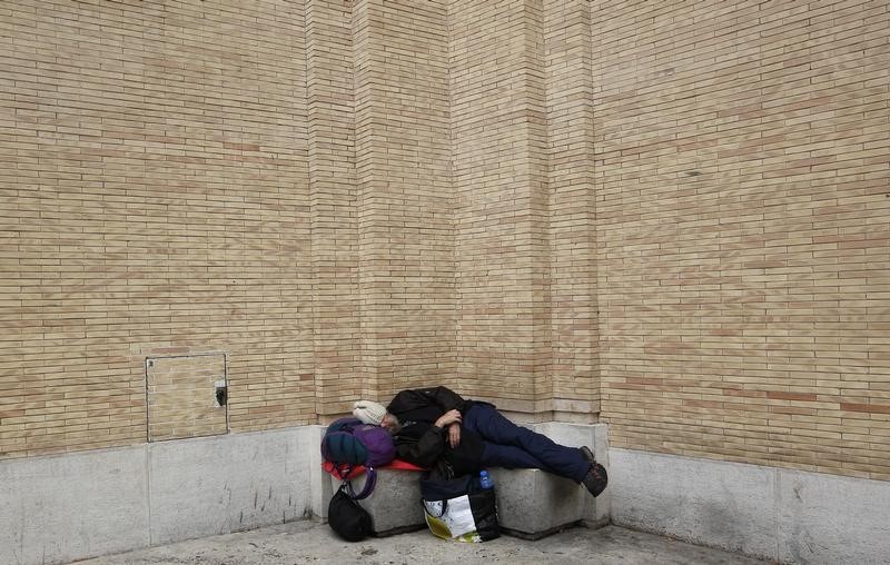 © Reuters. Un senza tetto dorme in strada nei pressi di San Pietro a Roma 