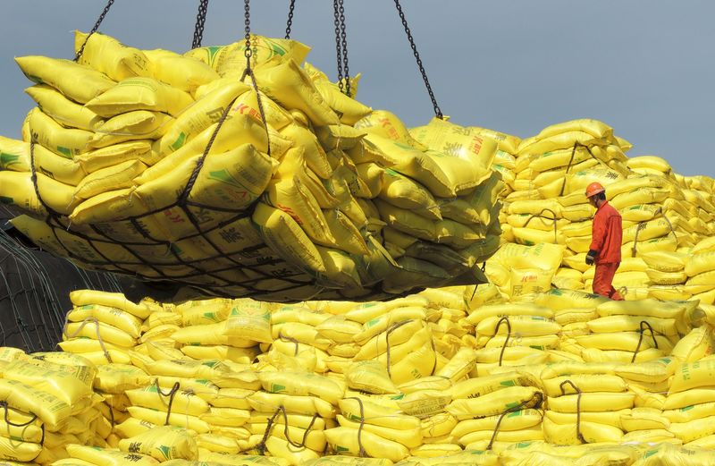 © Reuters. Trabalhador sobre pilha de produtos no porto chinês de Lianyungang