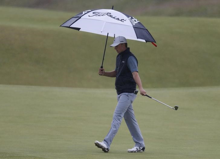 © Reuters. Spieth of the U.S. carries an umbrella as he walks across the fifth green during a practice round ahead of the British Open golf championship on the Old Course in St. Andrews, Scotland