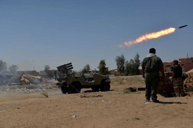 © Reuters. Shiite fighters launch a rocket towards Islamic State militants on the outskirt of Bayji