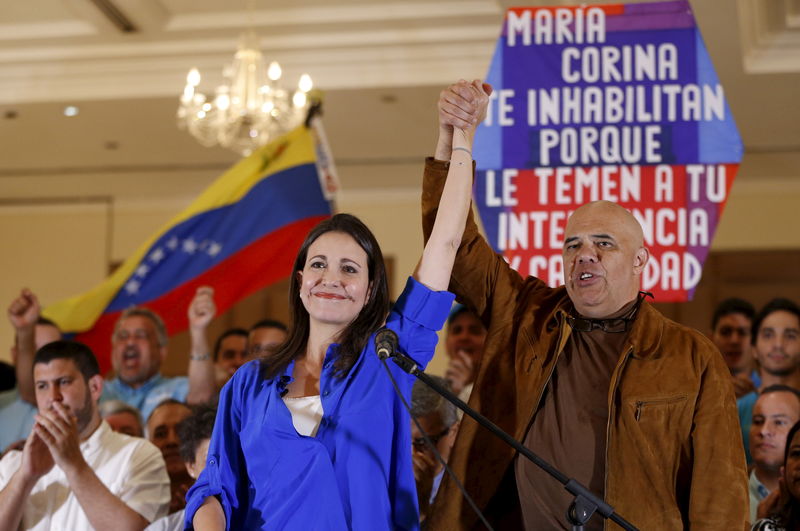 © Reuters. Venezuela's opposition leader Maria Corina Machado and Jesus Torrealba, secretary of the Venezuelan coalition of opposition parties (MUD) hold their hands, during a news conference in Caracas