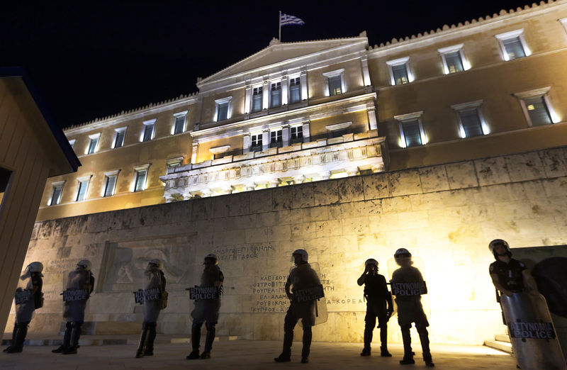 © Reuters. Riot policemen stand guard in front of the Greek Parliament during clashes in Athens