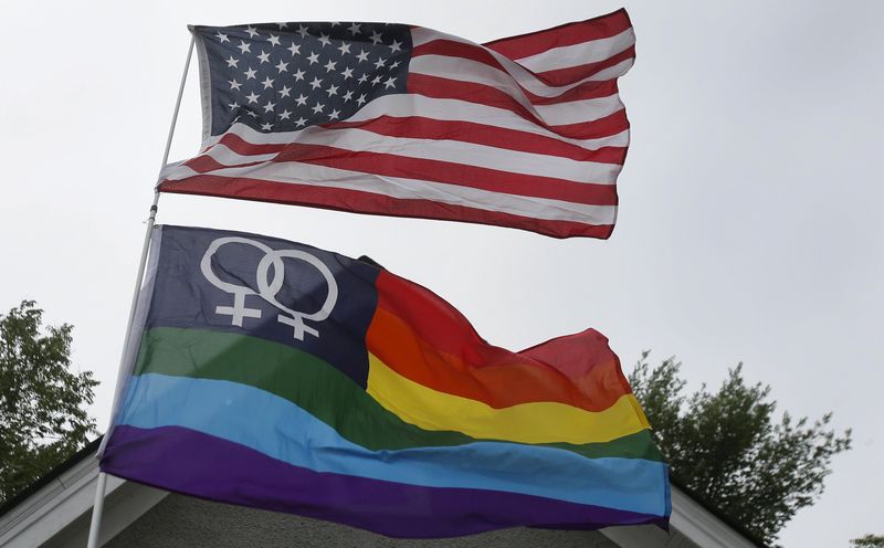© Reuters. A Gay Pride flag flies below the U.S. flag during a celebration of the U.S. Supreme Court's landmark ruling of legalizing gay marriage nationwide, at a rally in Ann Arbor