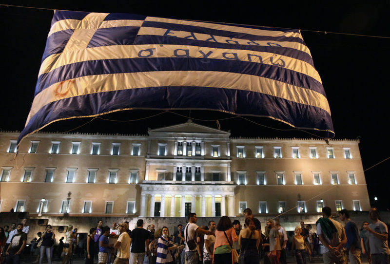 © Reuters. Manifestantes antiausteridade levantam uma bandeira da Grécia em frente ao Parlamento em Atenas