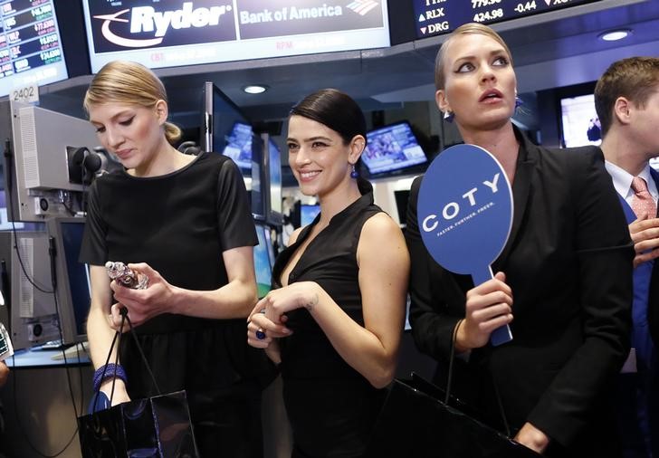 © Reuters. Models gather at a trading post on the floor of the New York Stock Exchange for the IPO of Coty Inc.