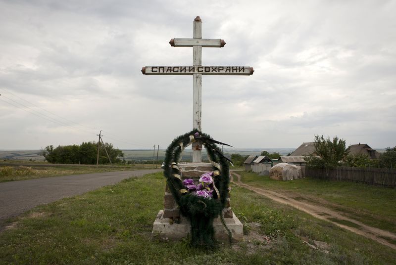 © Reuters. A wreath is placed on a cross with an inscription that reads "Save and protect" next to the site of the downed Malaysia Airlines flight MH17, near the village of Hrabove (Grabovo) in Donetsk region, eastern Ukraine