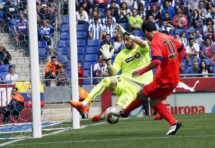 © Reuters. Barcelona's Lionel Messi scores his goal against Espanyol's goalkeeper Kiko Casillas during their Spanish first division soccer match at Power8 stadium in Cornella de Llobregat near Barcelona