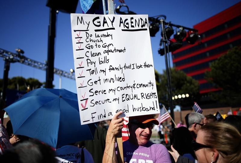 © Reuters. A man holds a sign at a rally in West Hollywood, after the United States Supreme Court ruled on California's Proposition 8 and the federal DOMA