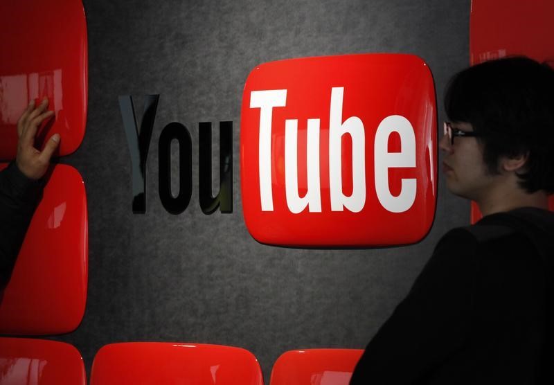 © Reuters. Visitors stand in front of a logo of YouTube at the YouTube Space Tokyo, operated by Google, in Tokyo