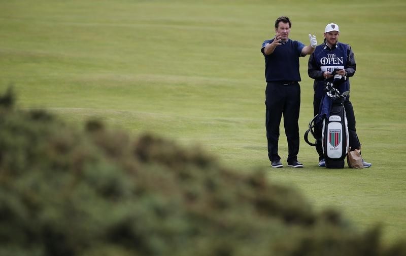 © Reuters. Faldo of England (L)  talks with his caddie as he stands on the fourth fairway during the second round of the British Open golf championship on the Old Course in St. Andrews, Scotland