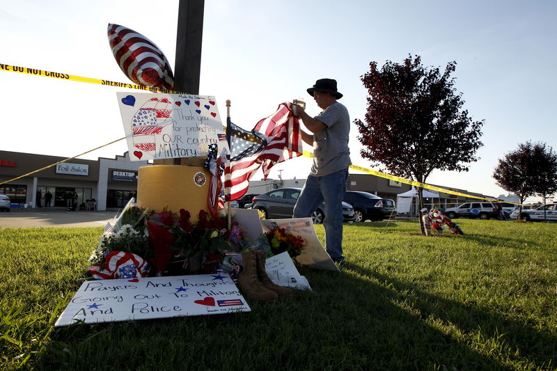 © Reuters. En la imagen de archivo, un hombre manipula una bandera en un memorial frente a un centro de reclutamiento militar en Chattanooga